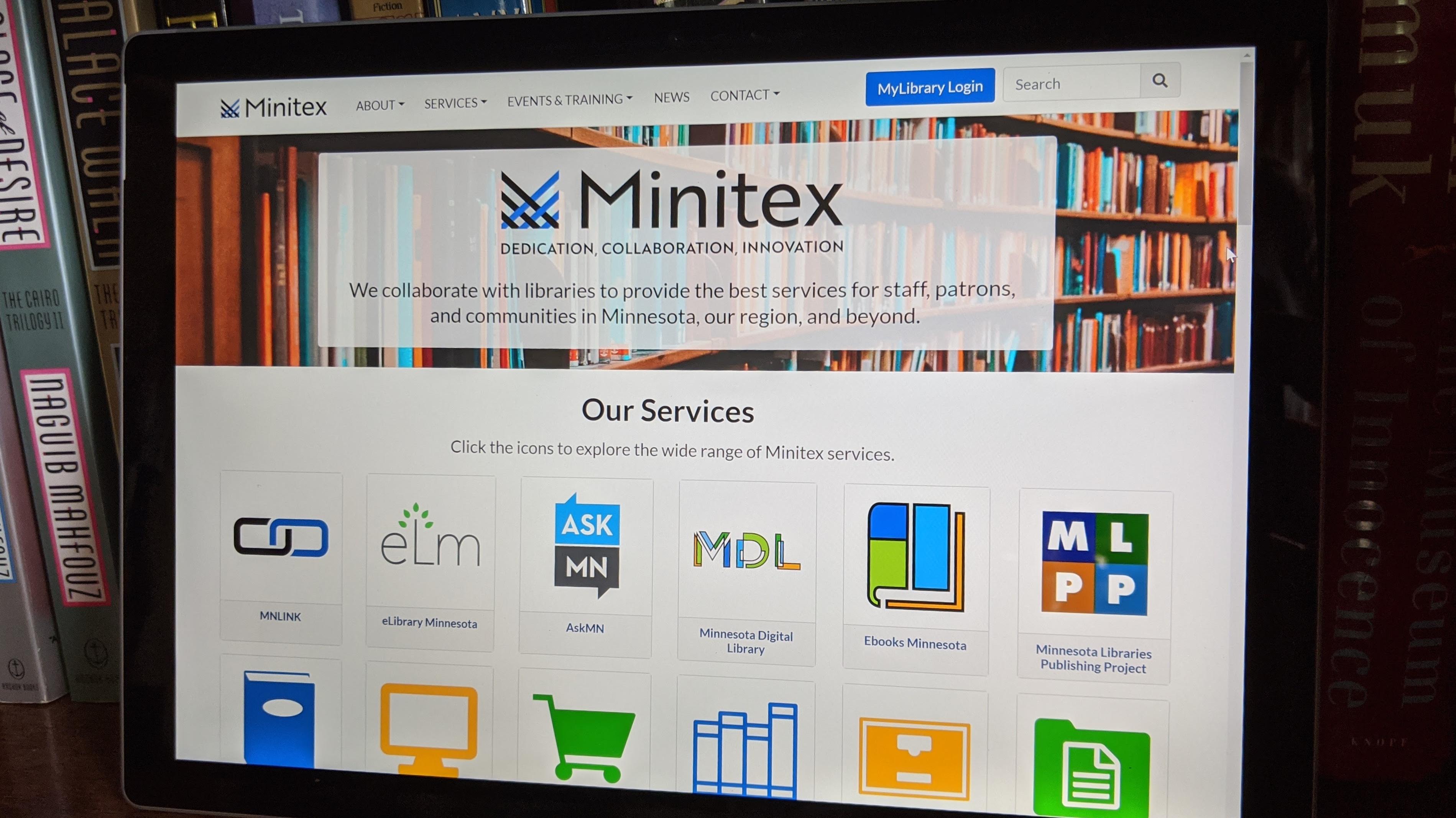 A photograph of a computer screen set to the homepage of the new Minitex website.