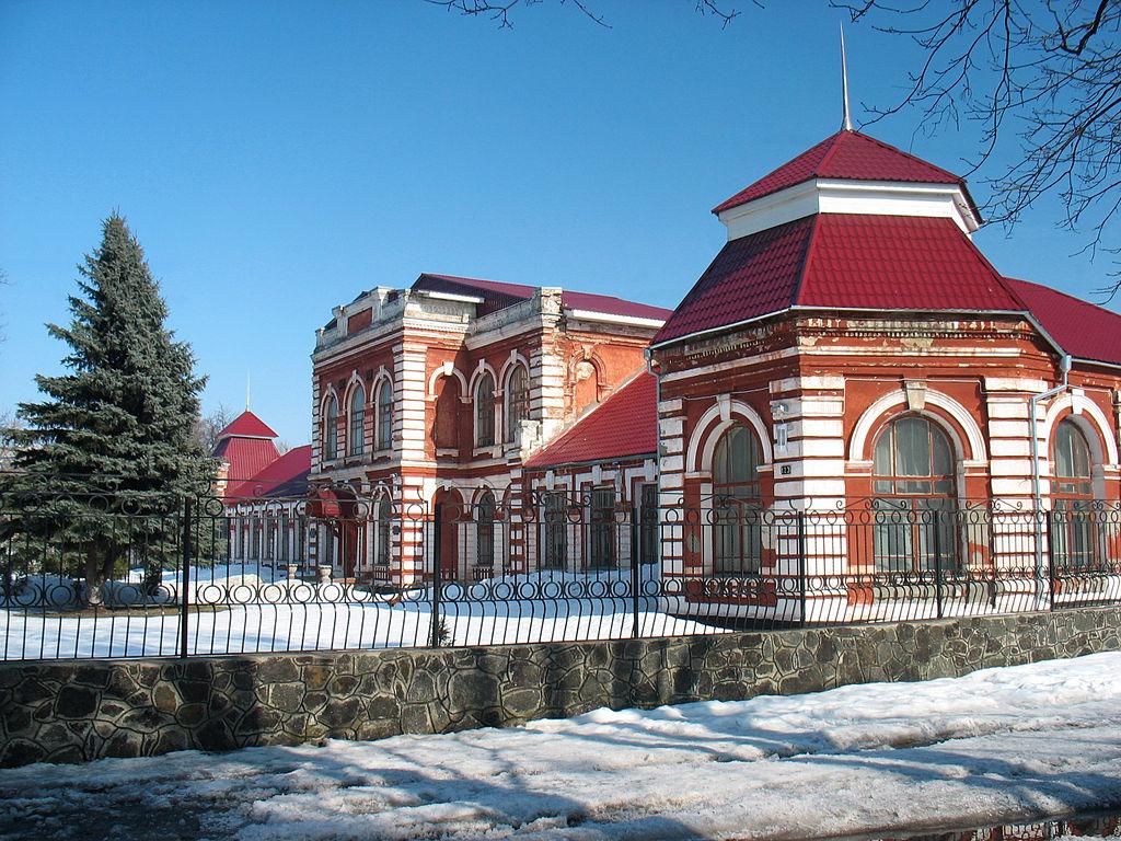 A photograph of a red and white brick romanesque women's gymnasium in Smila, Ukraine.