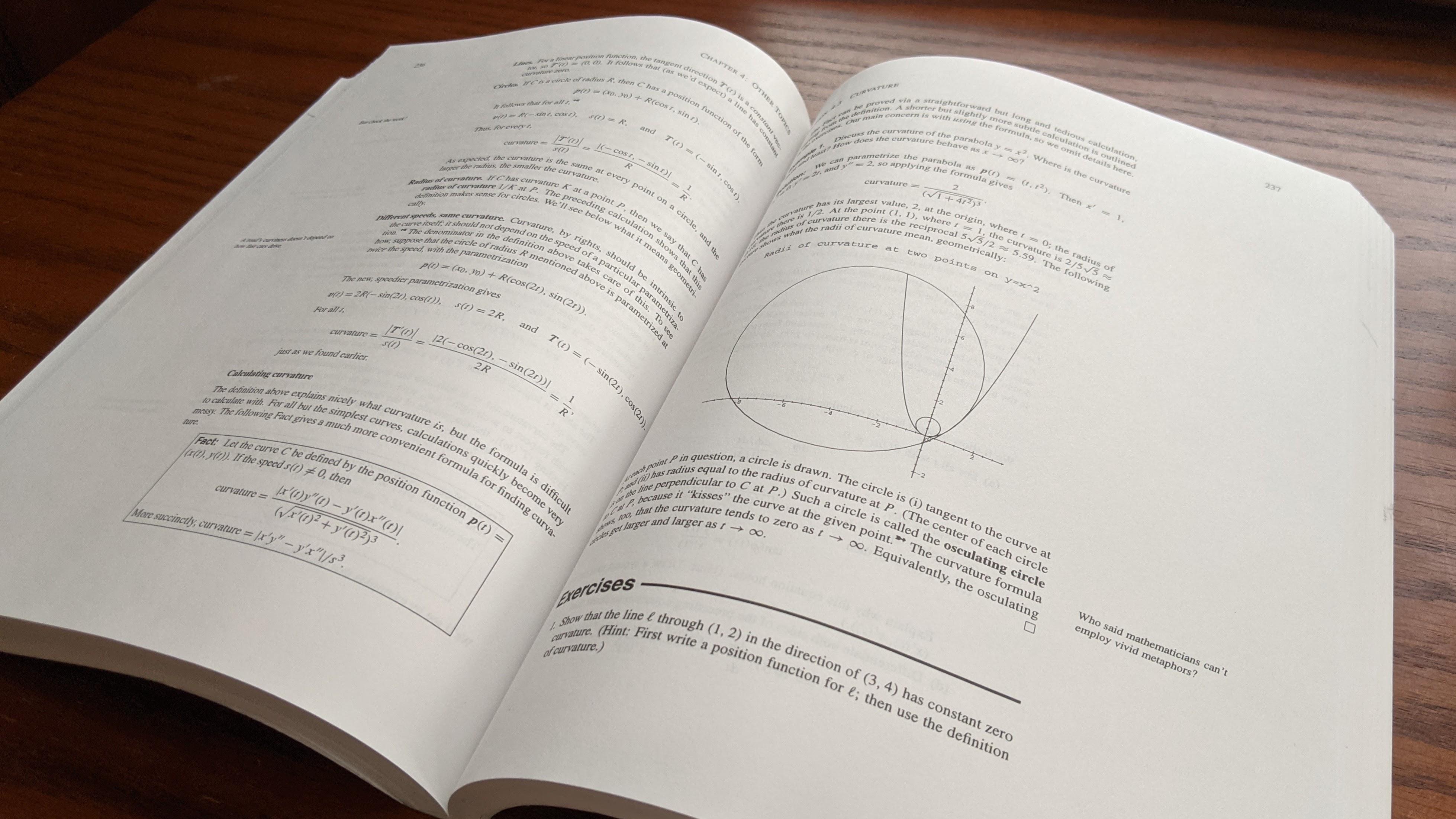 A photograph of a multivariable calculus sitting open on a wooden desktop.