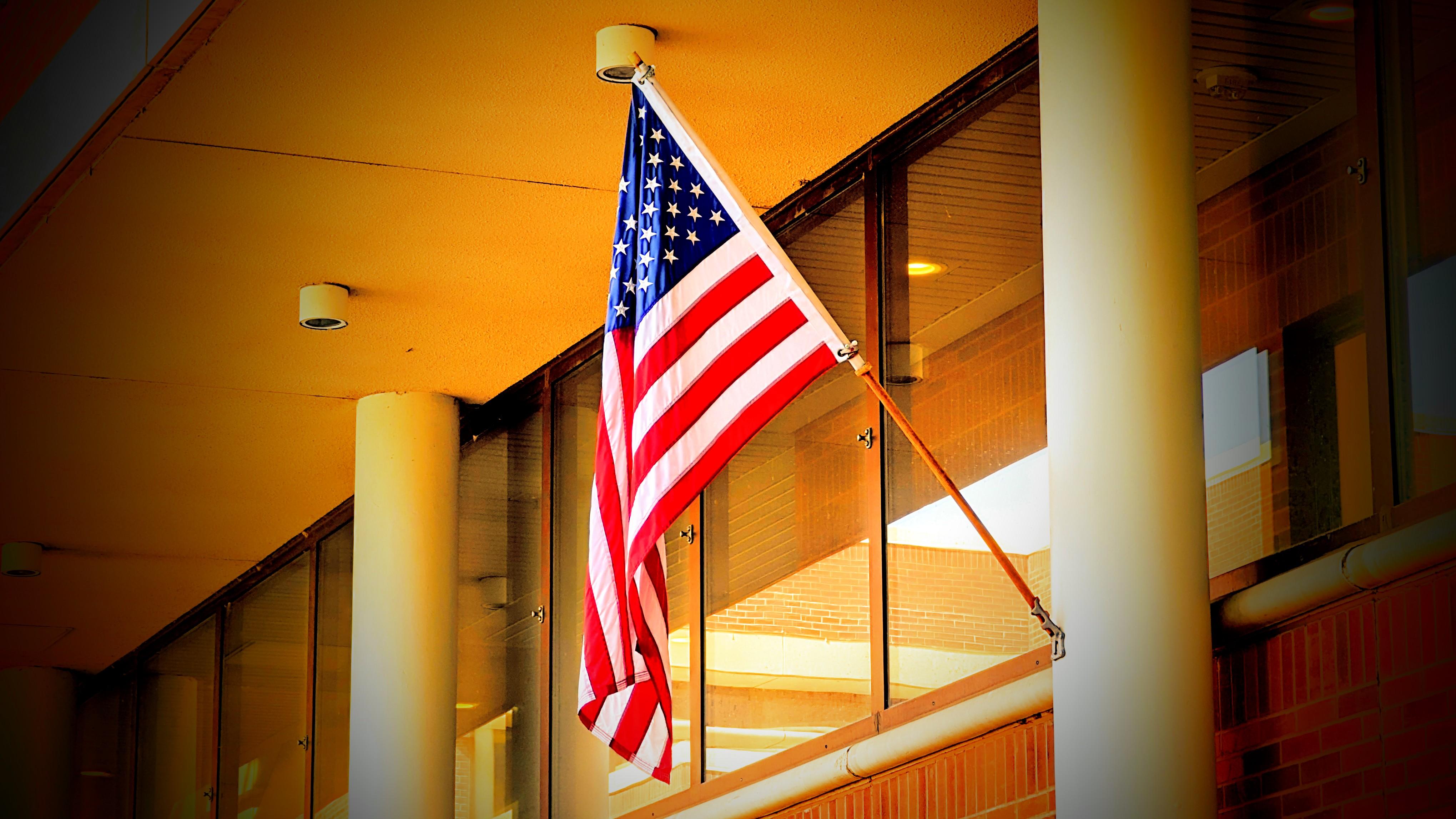 A photograph of an American flag on the front of an office building.