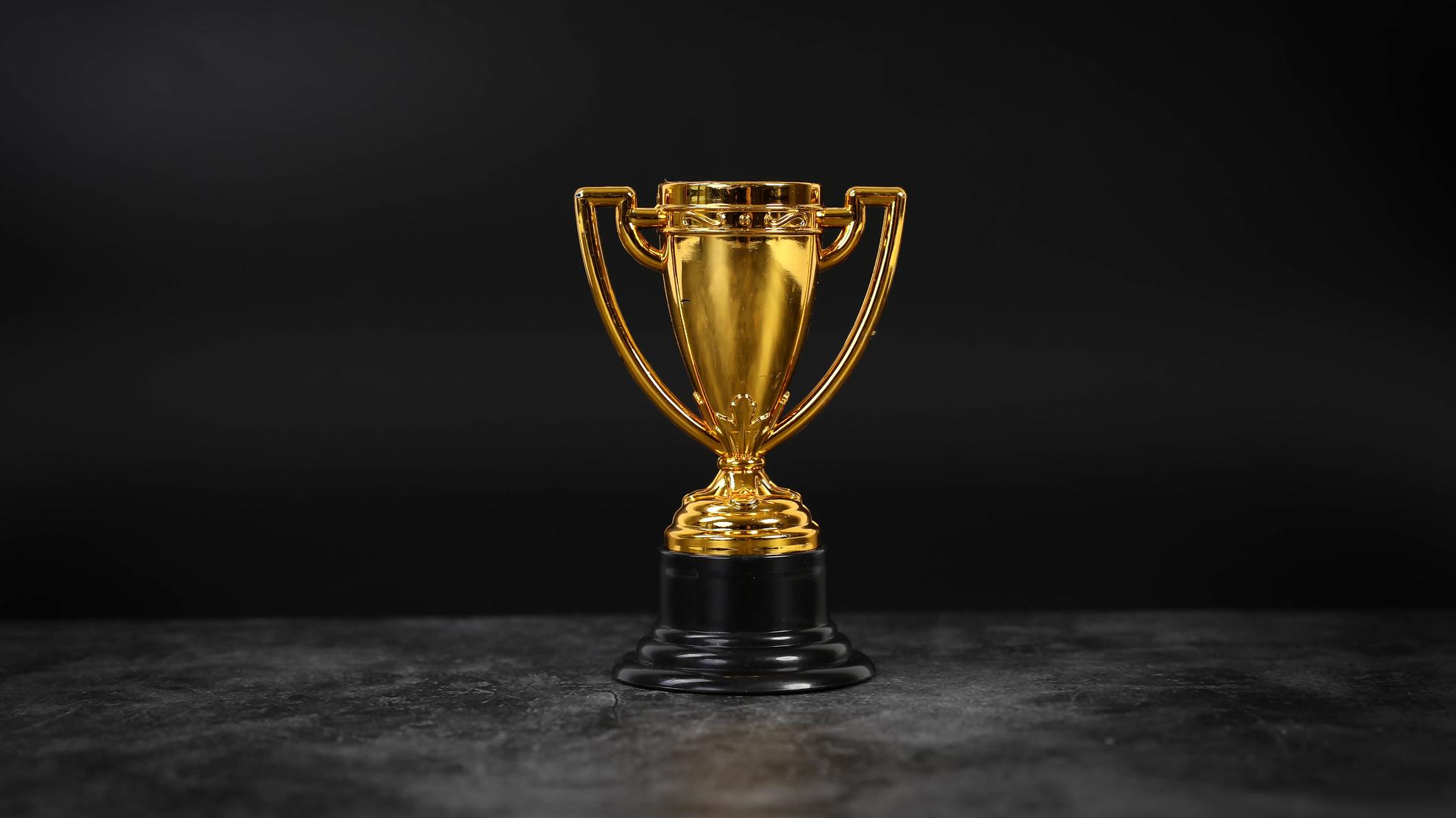 Golden trophy on a black background.