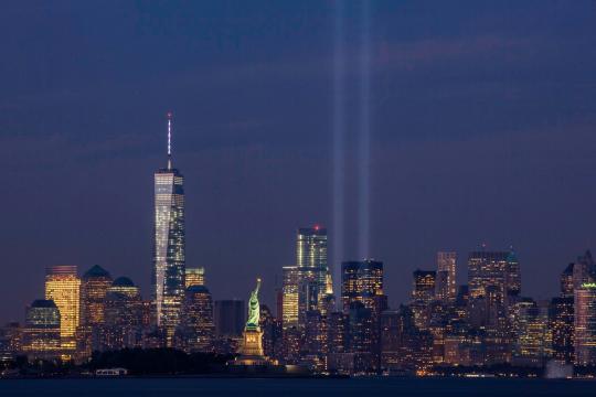 A photograph of the New York City skyline at night, including two beams of light commemorating the fallen towers of the World Trade Center.