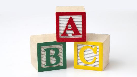 A, B , and C kids building blocks stacked on stop of each other in red, green, and yellow