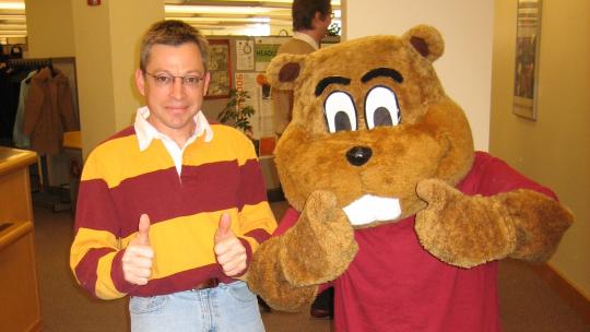 A photograph of Nick Banitt in a maroon and yellow striped shirt with Goldy Gopher.