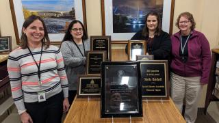 Four staff members from the MnDOT Library pose with award plaques.