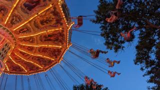 Children enjoying a ride at the State Fair at dusk.