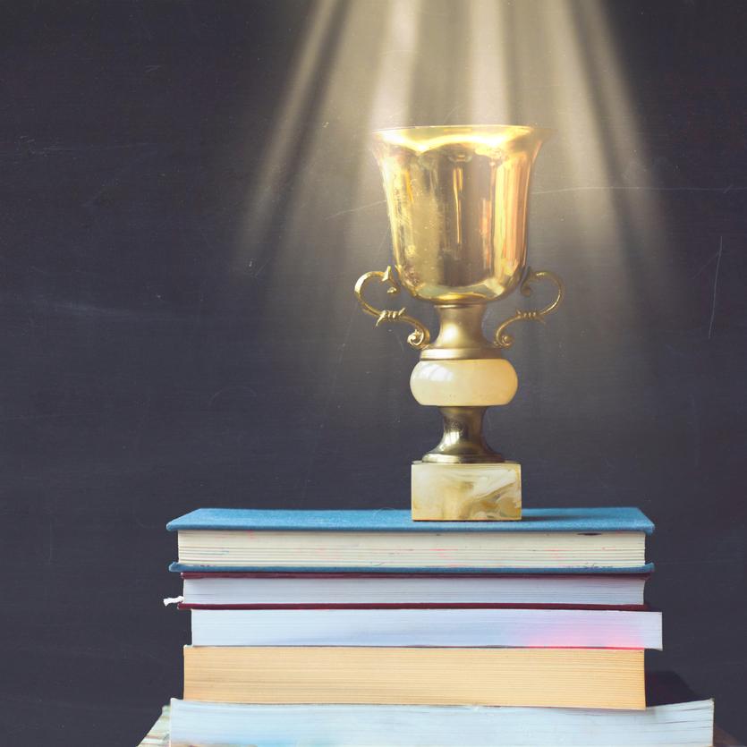 Golden trophy on a pile of books