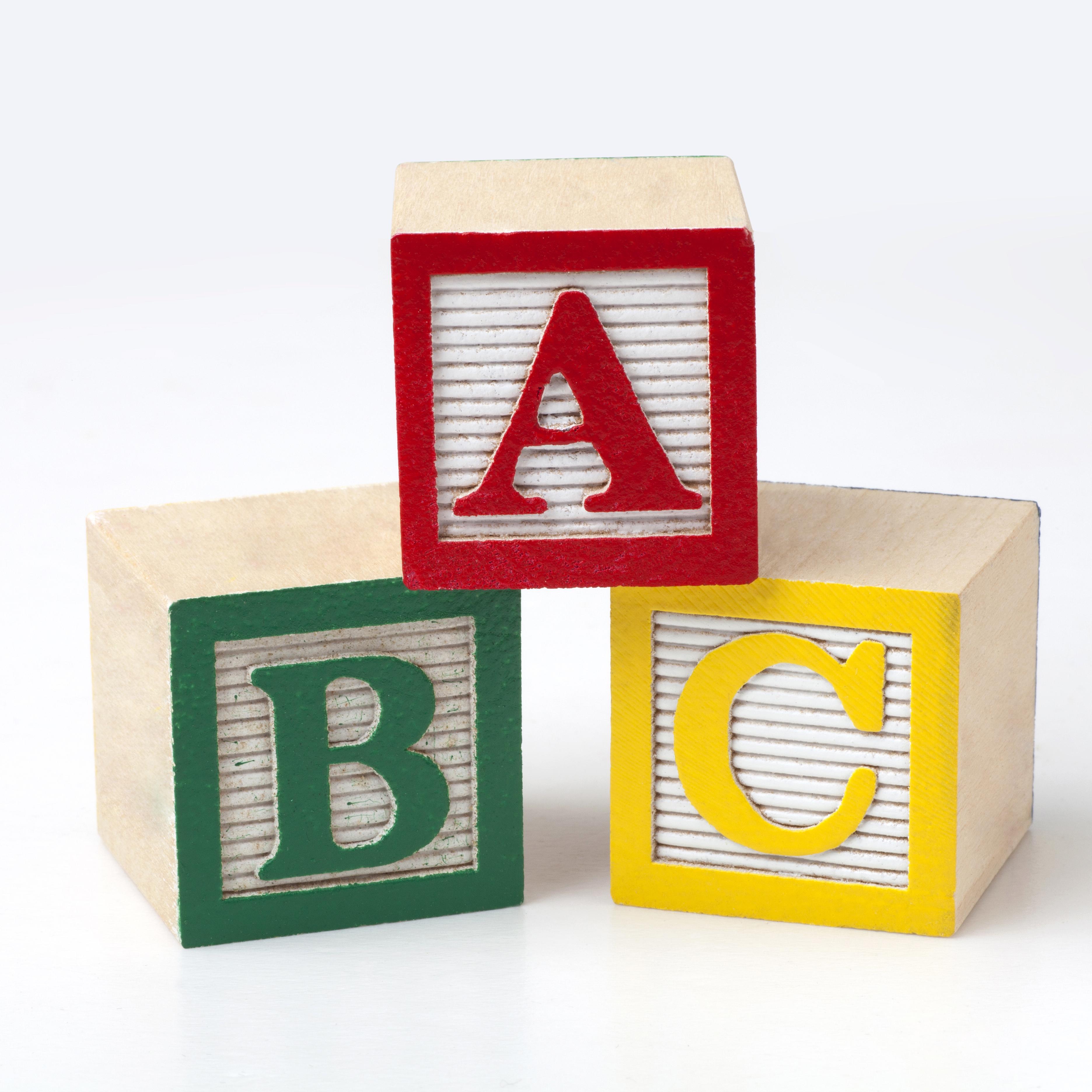A, B , and C kids building blocks stacked on stop of each other in red, green, and yellow