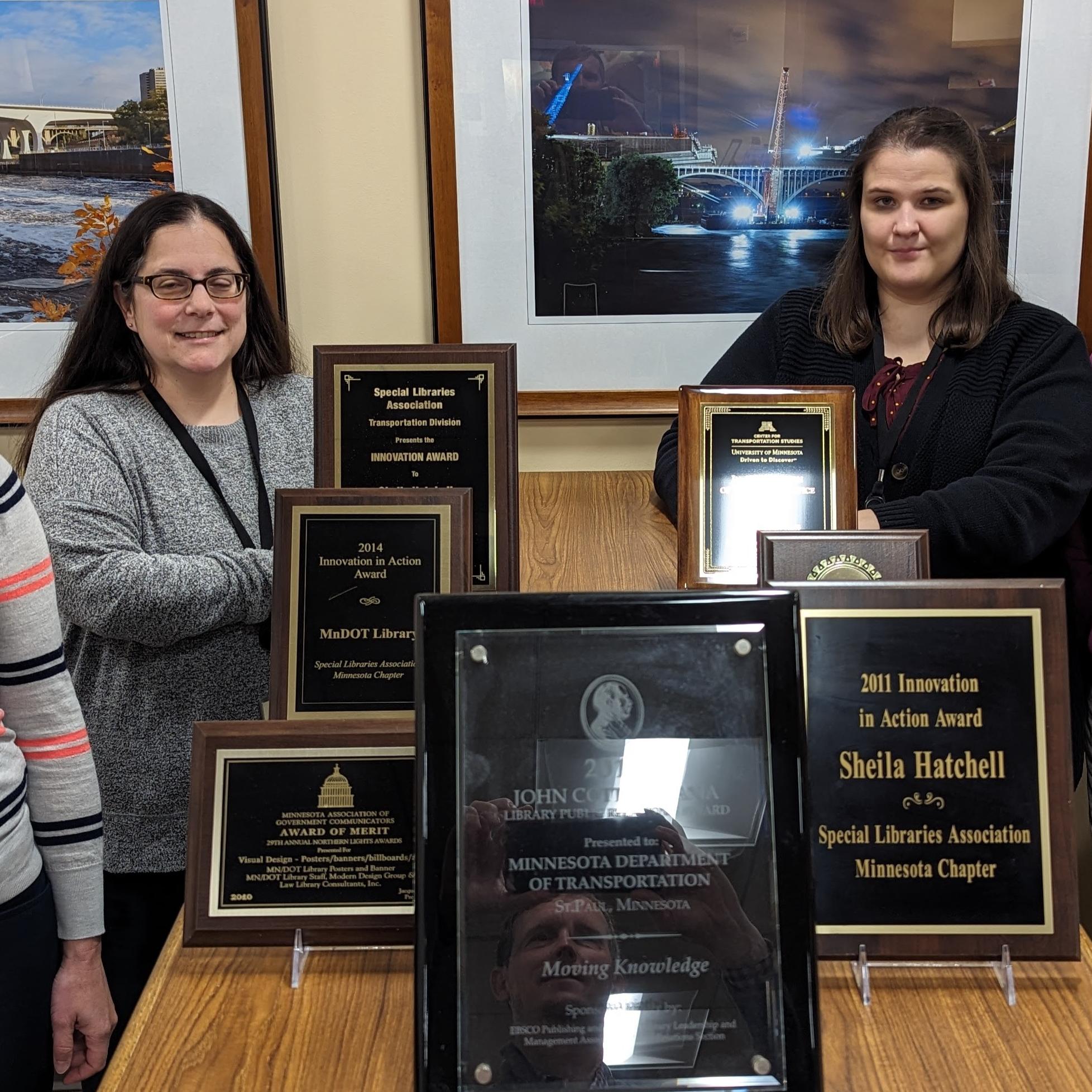 Four staff members from the MnDOT Library pose with award plaques.